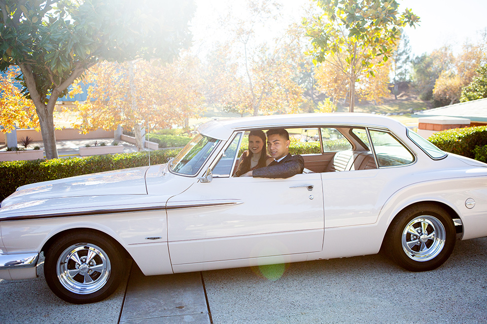 prom dates in car in paisley tuxedo with maroon accessories