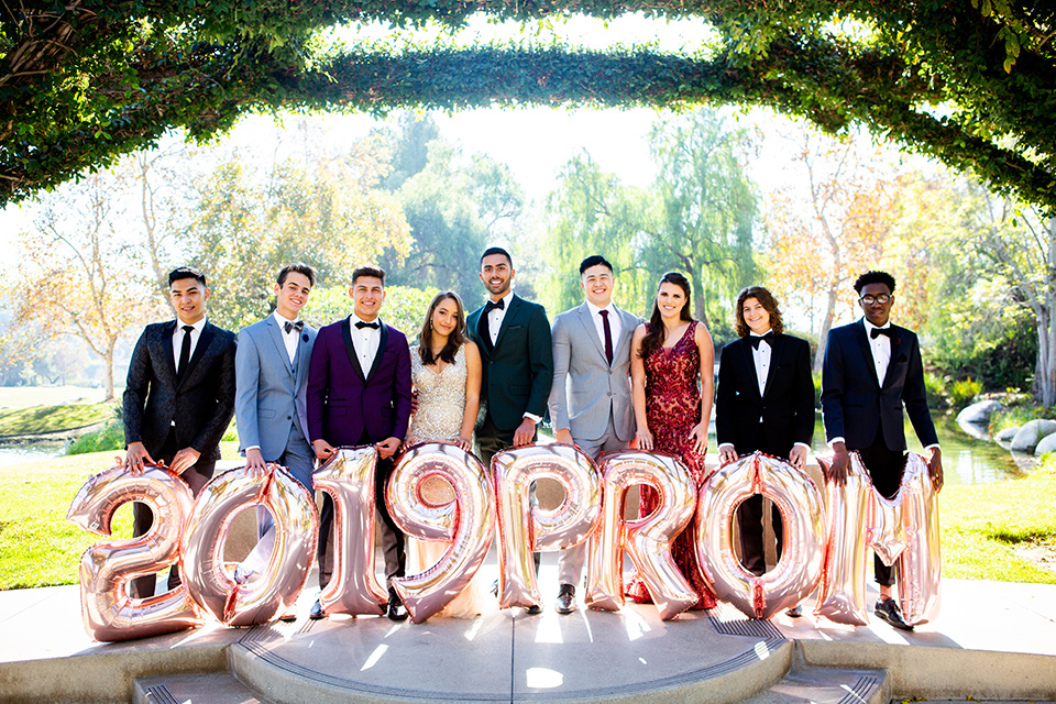 Group of friends pose for 2019 prom photo outdoors