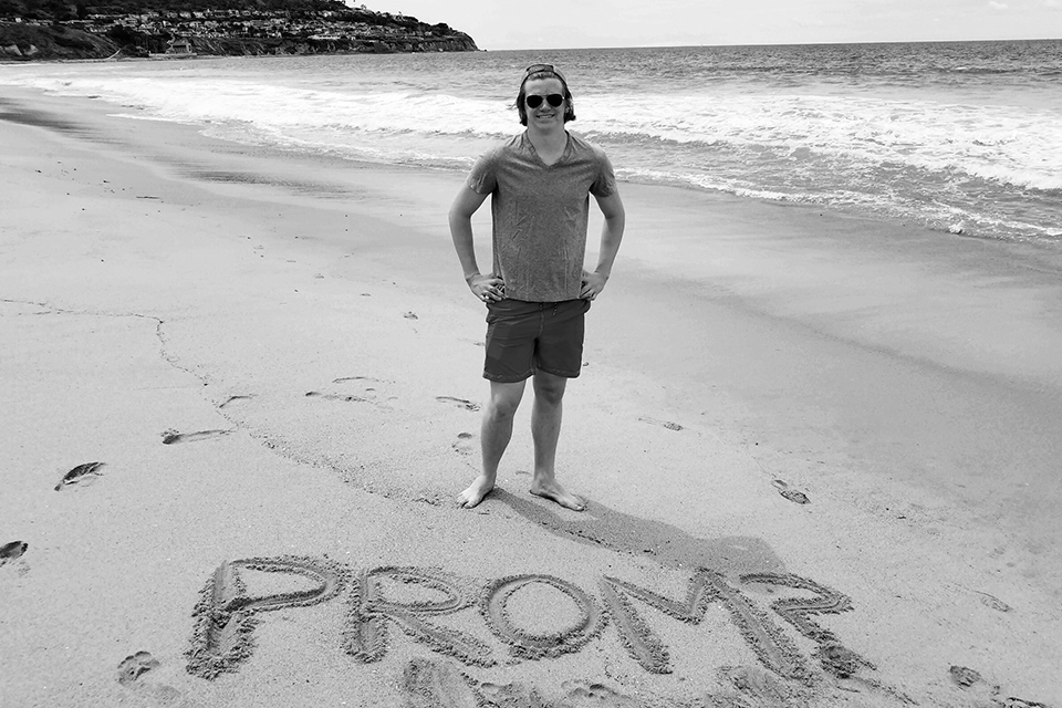 promposal: guy spells out prom in sand at beach