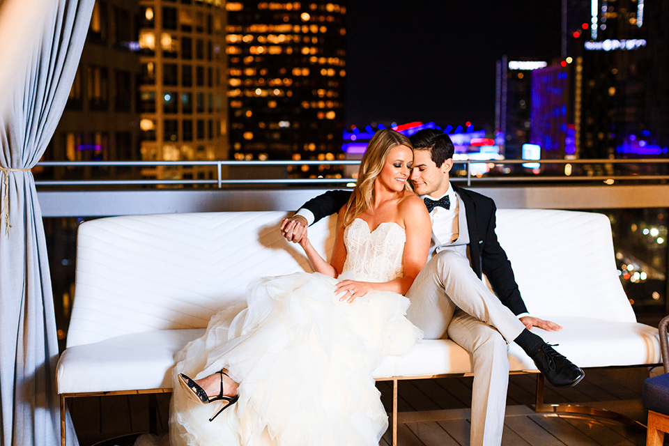 Intercontinental-DTLA-shoot-bride-and-groom-on-white-couch-bride-wearing-a-stapless-white-gown-with-lace-detail-and-the-groom-wearing-a-two-toned-tuxedo-in-black-and-grey