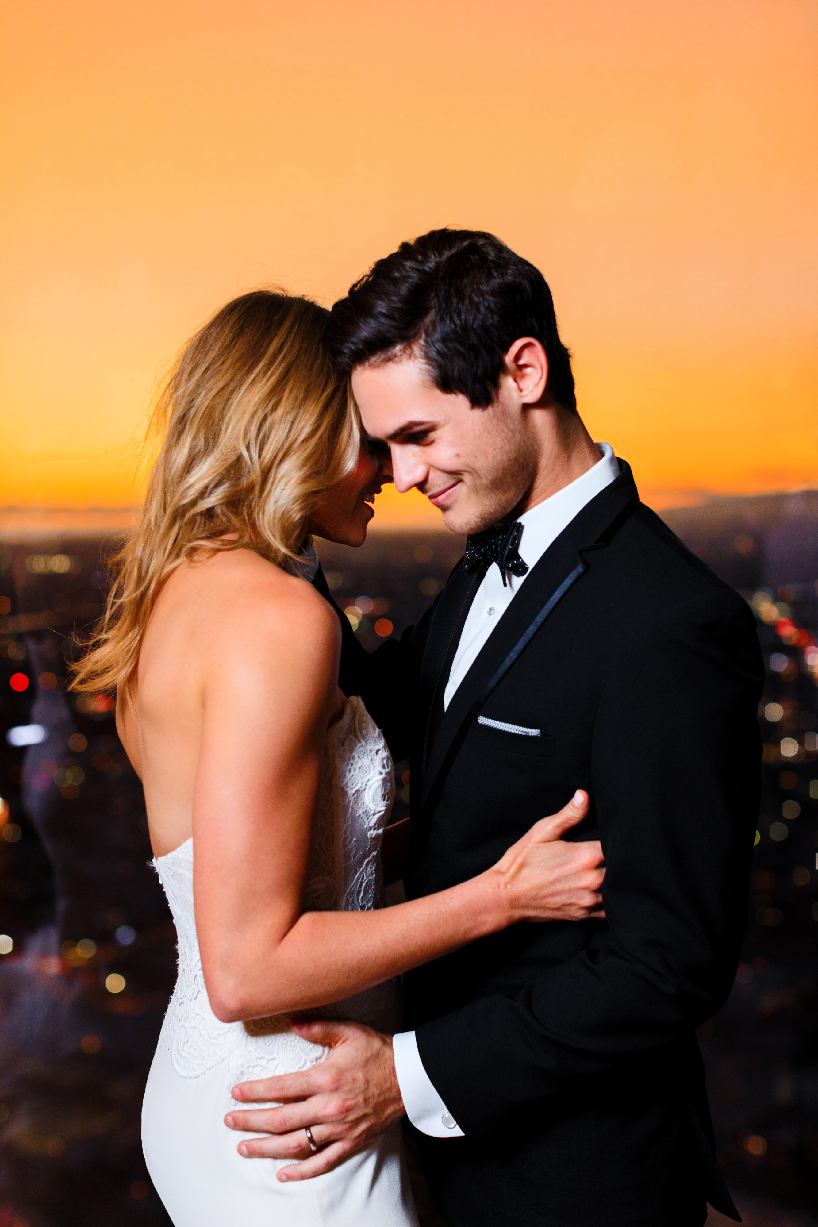 Intercontinental-DTLA-shoot-bride-and-groom-with-orange-sky-behind-them-bride-in-a-mermaid-gown-and-groom-in-a-black-tuxedo