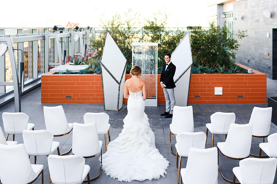 Intercontinental-DTLA-shoot-bride-walking-down-the-aisle-bride-wearing-a-stapless-white-gown-with-lace-detail-and-the-groom-wearing-a-two-toned-tuxedo-in-black-and-grey