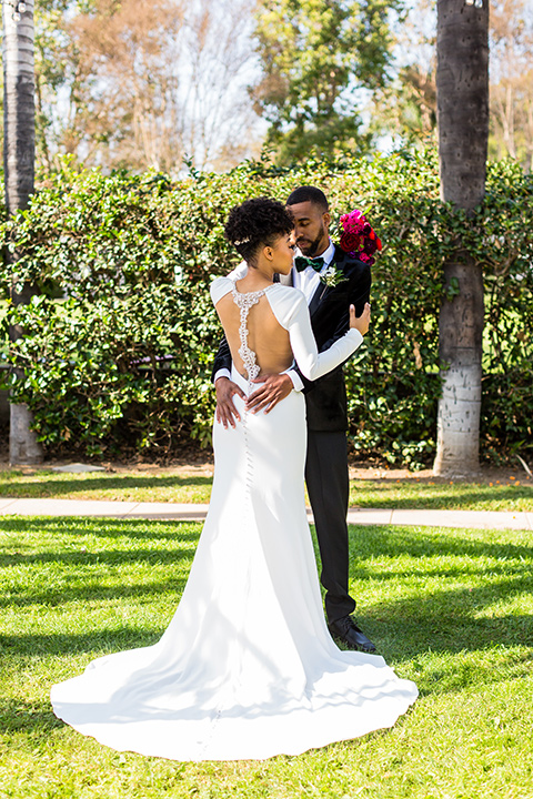 muckenthaler-mansion-bride-and-groom-dancing-in-a-satin-white-gown-and-long-sleeves-and-groom-in-a-black-velvet-tuxedo-and-green-velvet-bow-tie