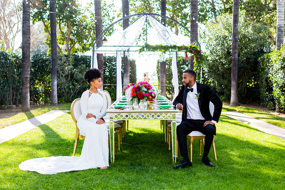 muckenthaler-mansion-bride-groom-at-table-bride-in-a-vintage-satin-gown-and-groom-in-a-velvet-tuxedo-with-a-green-velvet-bow-tie