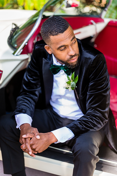 muckenthaler-mansion-groom-sitting-in-car-groom-in-a-black-velvet-tuxedo-and-green-velvet-bow-tie