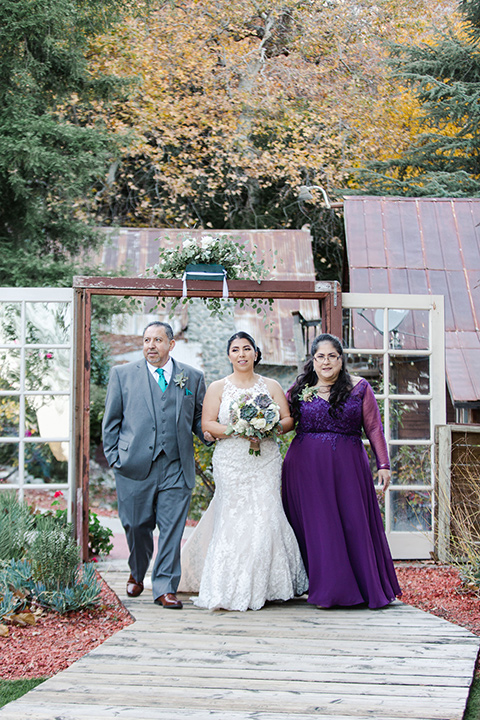 hidden-acres-wedding-bride-walking-down-aisle-bride-in-a-fitted-lace-gown-with-groom-in-grey-suit-with-white-bow-tie