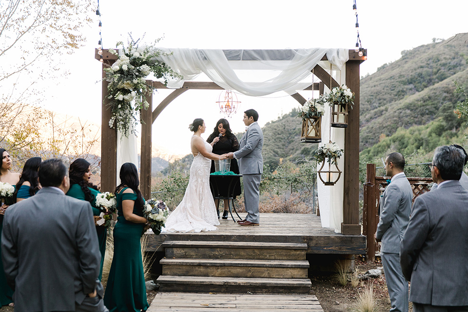 hidden-acres-wedding-ceremony-bride-in-fitted-gown-with-an-illusion-neckline-and-groom-in-a-grey-suit-with-a-white-bow-tie