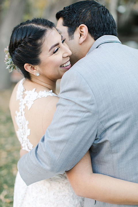 hidden-acres-wedding-close-up-on-bride-and-groom-bride-in-a-fitted-lace-gown-with-groom-in-grey-suit-with-white-bow-tie