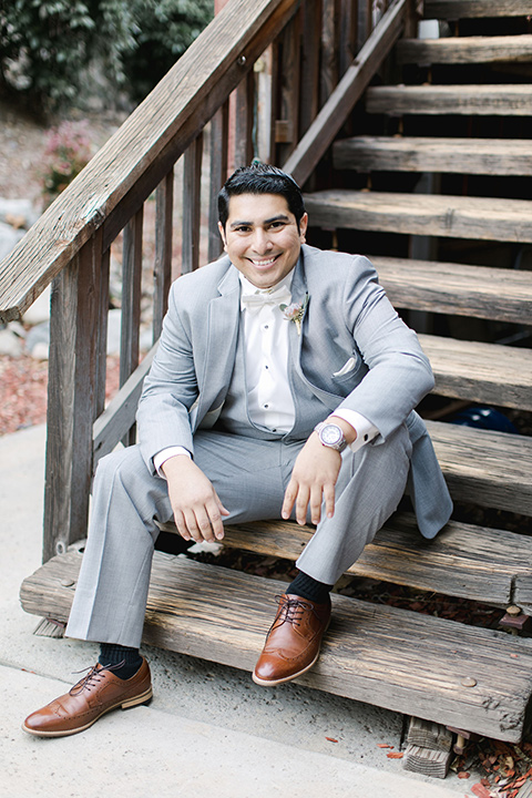 hidden-acres-wedding-groom-sitting-on-steps-groom-in-light-grey-suit