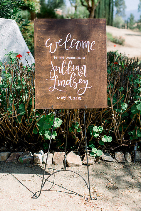  wooden sign with the bride and groom welcoming guests