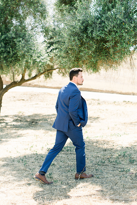  the groom in a dark blue suit with a white bow tie 
