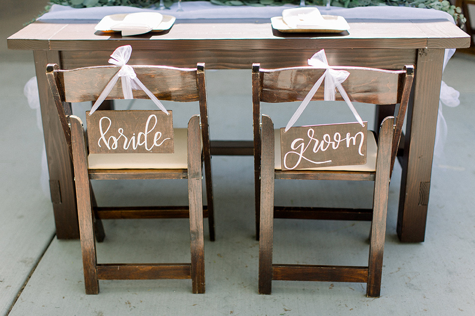 wooden table with wooden signs with bride and groom written on them 