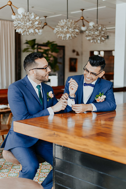 loquita-shoot-close-up-of-grooms-at-bar-grooms-in-cobalt-blue-suits-with-a-green-tie-and-a-blue-bow-tie