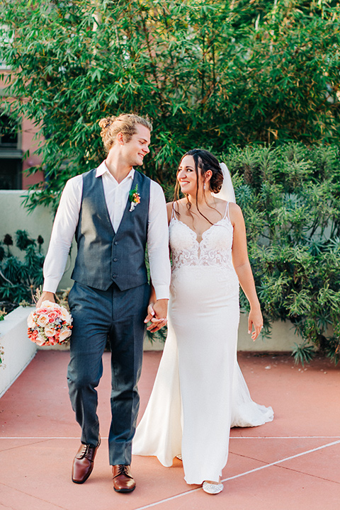 San-Diego-Beach-wedding-bride-and-groom-walking-groom-in-a-grey-suit-pant-and-vest-bride-in-a-casual-lace-gown