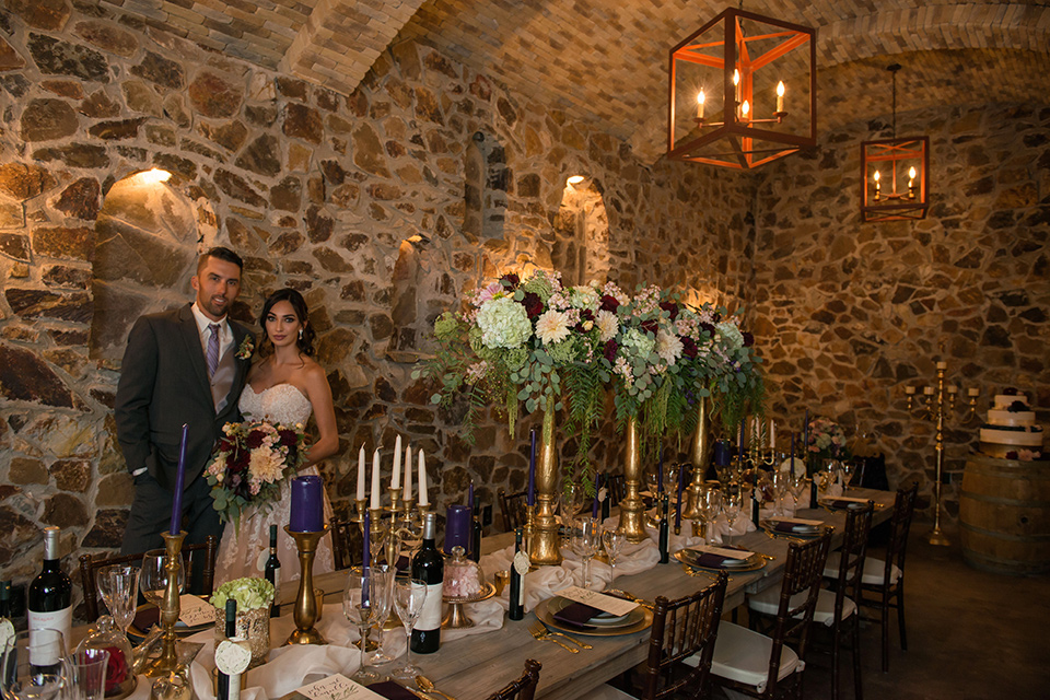 milagro-farms-shoot-bride-and-groom-in-cavern-bride-in-a-fitted-lace-dress-groom-in-charcoal-suit-with-purple-tie