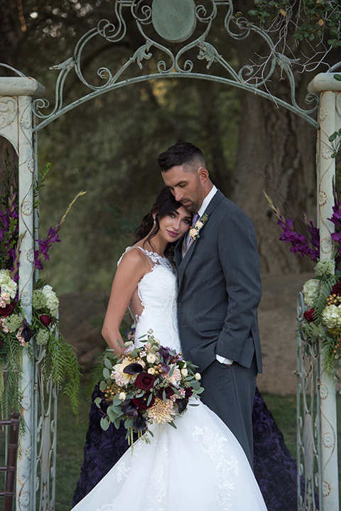 milagro-farms-shoot-couple-at-ceremony-sace-bride-in-a-fitted-lace-gown-with-straps-groom-in-a-charcoal-suit-with-a-purple-tie