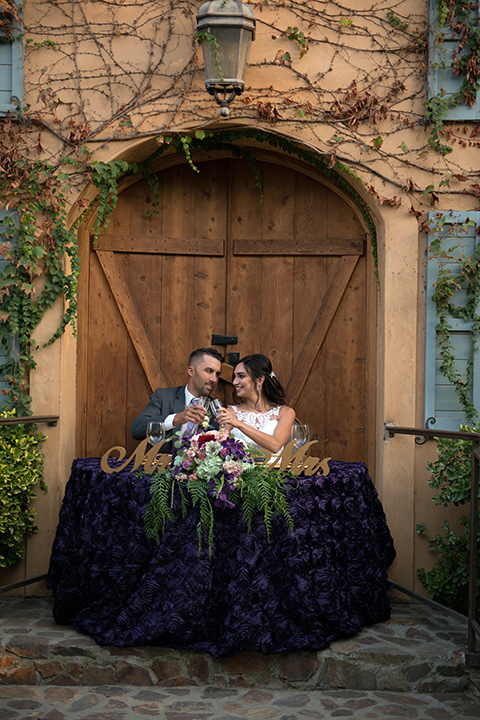 milagro-farms-shoot-sweetheart-table-bride-in-a-fitted-lace-gown-with-straps-groom-in-a-charcoal-suit-with-a-purple-tie