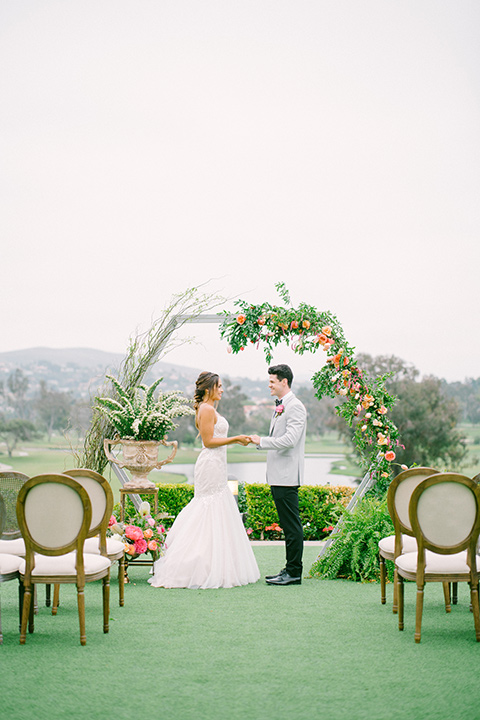 omni-la-costa-ceremony-space-bride-wearing-a-lace-fitted-gown-with-mermaid-style-with-thin-straps-groom-with-light-grey-jacket-with-black-pants-black-polka-dot-bowtie