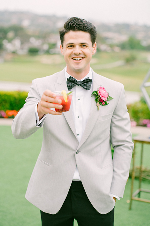 omni-la-costa-groom-with-drink-bride-wearing-a-lace-fitted-gown-with-mermaid-style-with-thin-straps-groom-with-light-grey-jacket-with-black-pants-black-polka-dot-bowtie