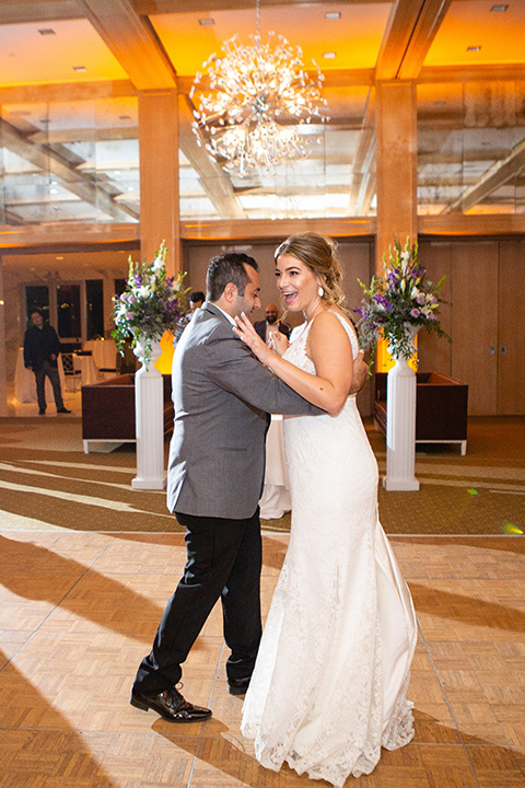 Palm-Springs-wedding-at-the-parker-bride-and-groom-dancing-bride-in-a-flowing-gown-and-a-deep-v-neckline-groom-in-grey-tuxedo-with-black-trim