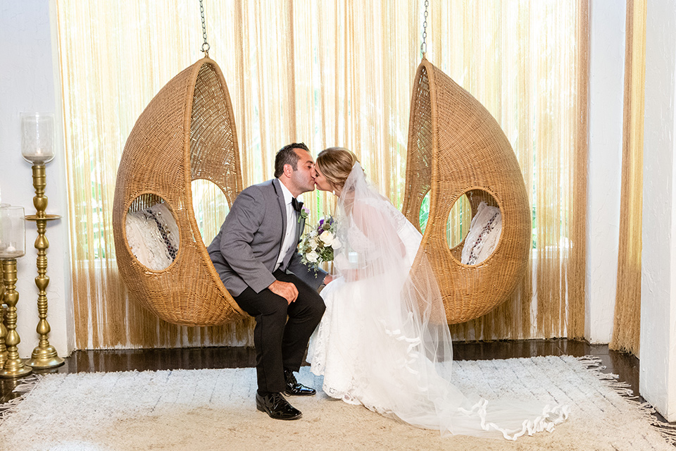 Palm-Springs-wedding-at-the-parker-bride-and-groom-in-egg-shapped-furniture-bride-in-a-flowing-gown-with-straps-and-a-plunging-deep-v-neckline-groom-in-a-grey-tuxedo-with-black-trim-and-black-pants