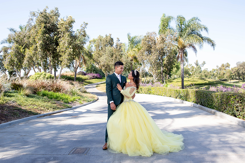 quince-shoot-enchanted-garden-theme-birthday-girl-in-a-yellow-ballgown-and-the-chambelan-in-a-dark-green-suit