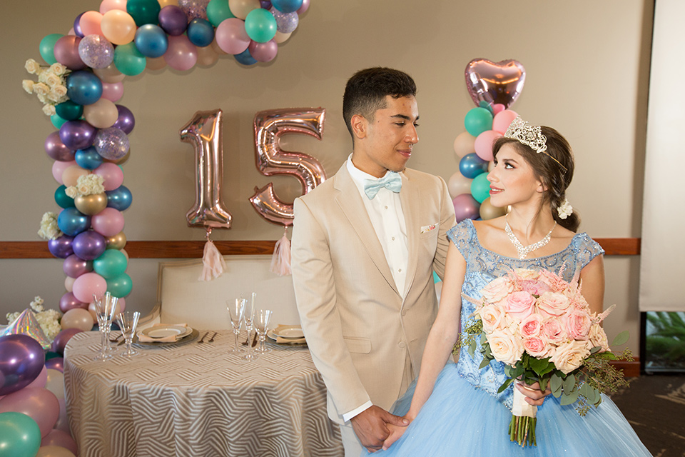 quince-shoot-pastel-color-scheme-quince-girl-in-a-light-blue-dress-with-a-cap-sleeve-chambelan-in-a-tan-suit-with-a-light-blue-bow-tie-to-match-her-dress