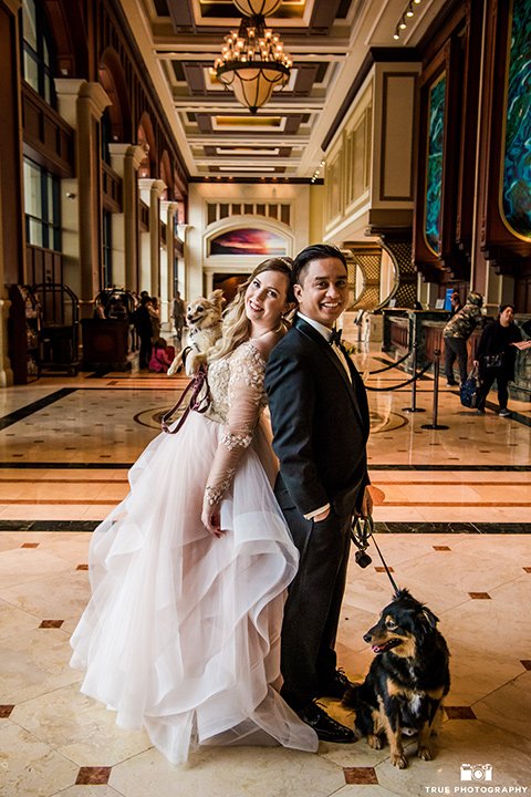 hyatt-san-diego-wedding-bride-and-groom-in-lobby-with-pets-the-bride-in-a-blush-ballgown-and-the-groom-in-a-black-tuxedo