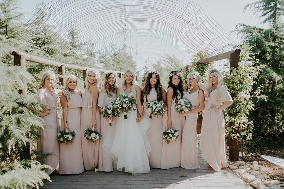 serendiity-gardens-bridesmaids-bride-in-a-tulle-ball-gown-with-straps-groom-in-grey-suit-with-brown-susenders-bridesmaids-in-pink-dresses