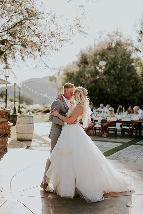 serendiity-gardens-first-dance-bride-in-a-tulle-ballgown-with-straps-groom-in-a-grey-suit-with-brown-suspenders