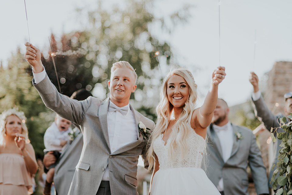 serendiity-gardens-sparklers-bride-in-a-tulle-ball-gown-with-straps-groom-in-grey-suit-with-brown-susenders-bridesmaids-in-pink-dresses-groomsmen-in-grey-suits