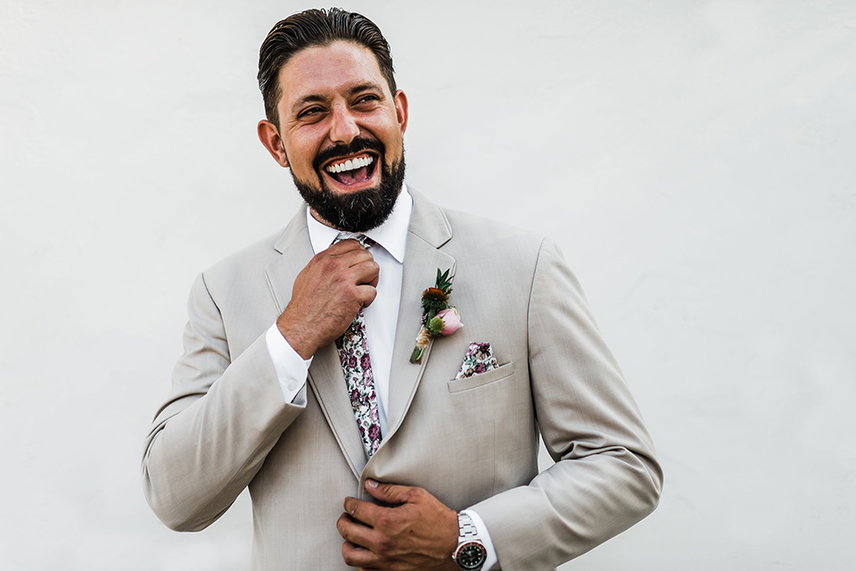 Olivas-Adobe-spanish-inspired-shoot-groom-laughing-in-a-tan-suit-with-a-floral-tie