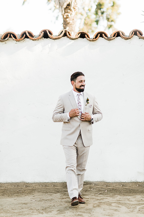 Olivas-Adobe-spanish-inspired-shoot-groom-walking-wearing-a-tan-suit-with-a-floral-tie