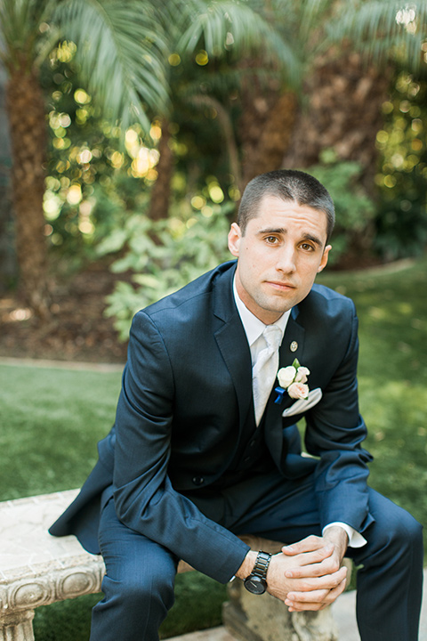 tropical-wedding-at-the-grand-tradition-groom-sitting-in-a-navy-suit-and-an-ivory-tie