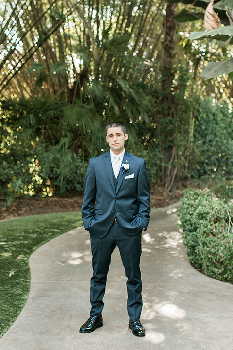 tropical-wedding-at-the-grand-tradition-groom-standing-in-a-navy-suit-and-an-ivory-tie