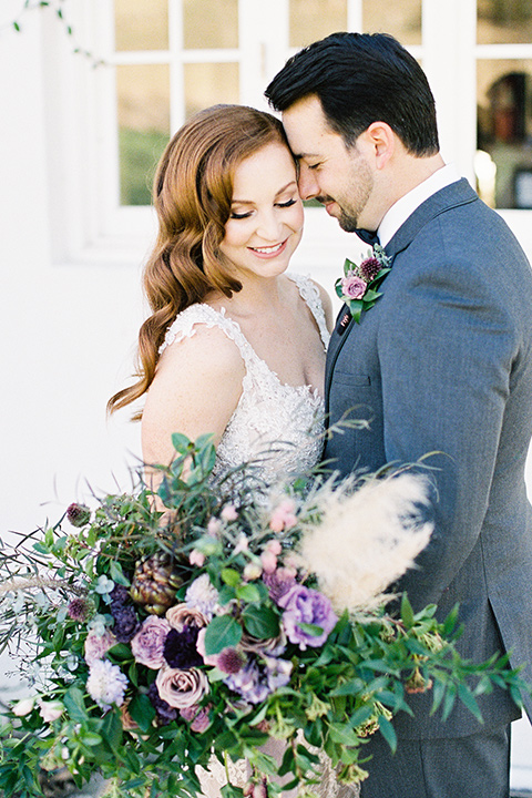 triunfo-creek-vineyards-wedding-close-up-of-bride-and-groom-bride-wearing-a-flowing-ivory-and-blush-gown-with-straps-and-a-sweetheart-neckline-groom-in-a-charcoal-grey-suit-with-a-lack-bowtie