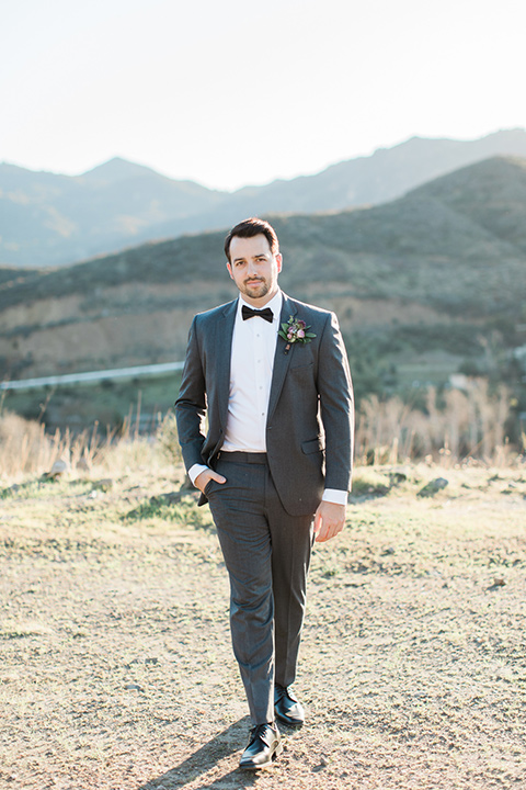 triunfo-creek-vineyards-wedding-groom-walking-towards-camera-in-a-dark-grey-tuxedo