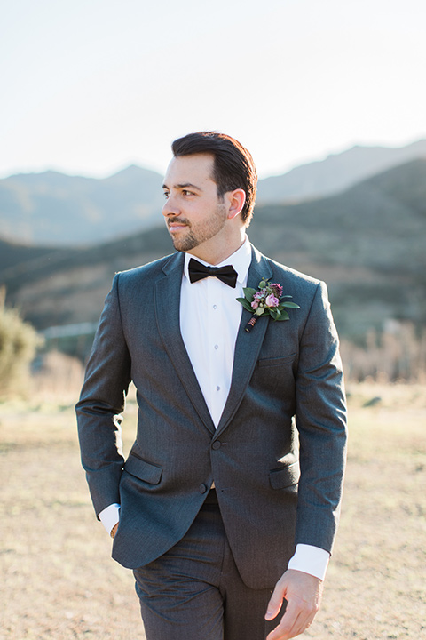 triunfo-creek-vineyards-wedding-groom-walking-groom-in-a-charcoal-grey-suit-with-a-lack-bowtie