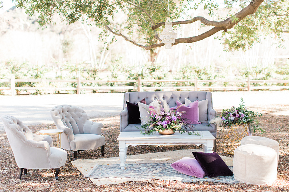 triunfo-creek-vineyards-wedding-outdoor-furniture-with-big-fluffy-purple-pillows-and-rugs-in-various-tones