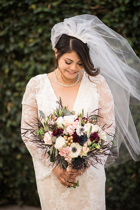 villa-del-sol-wedding-bride-looking-down-in-a-spanish-inspired-lace-gown-with-sleeves