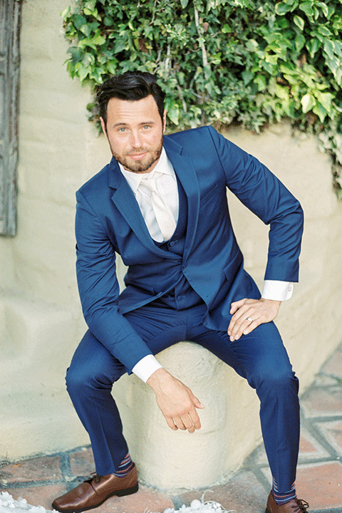 whispering-rose-shoot-groom-sitting-down-groom-in-a-cobalt-blue-suit-with-brown-shoes-and-an-ivory-tie