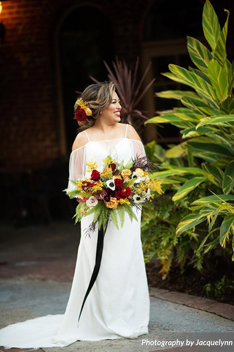  bride in a white silk gown with flowing sleeves and a high neckline