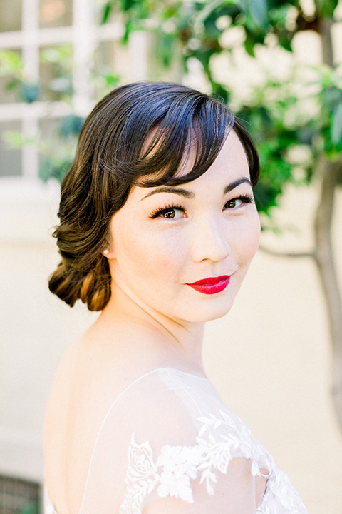  bride in a Spanish style white lace gown with sleeves and dee red lipstick 