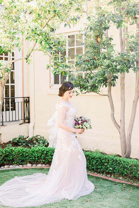  bride in a Spanish style white lace gown with sleeves and dee red lipstick