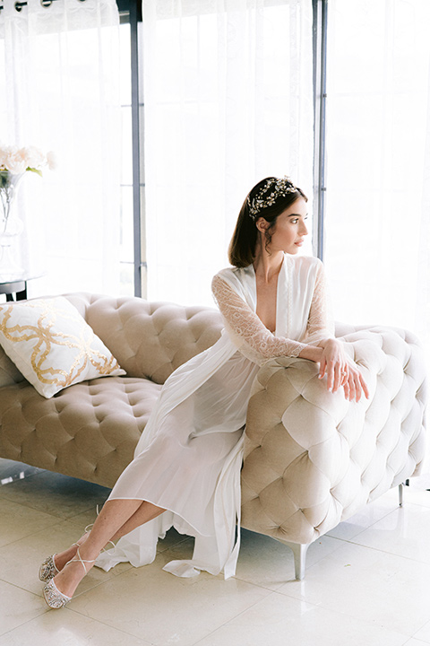  bride in robe looking out the window