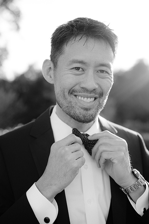  The groom in a black michael kors tuxedo with a black bow tie 