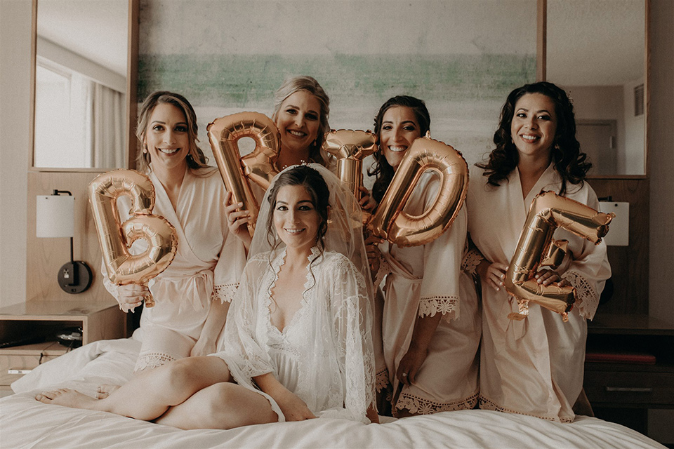  bride and bridesmaids in robes with gold balloons 