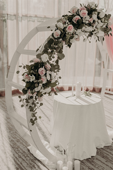  white ceremony arch with pink and green florals