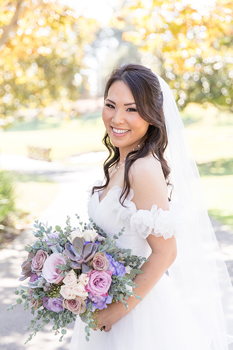  bride in a white a line gown with an off the shoulder neckline