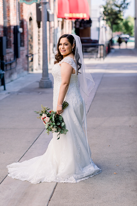  the bride in a lace a line gown with tulle cap sleeves and a modified sweetheart neckline